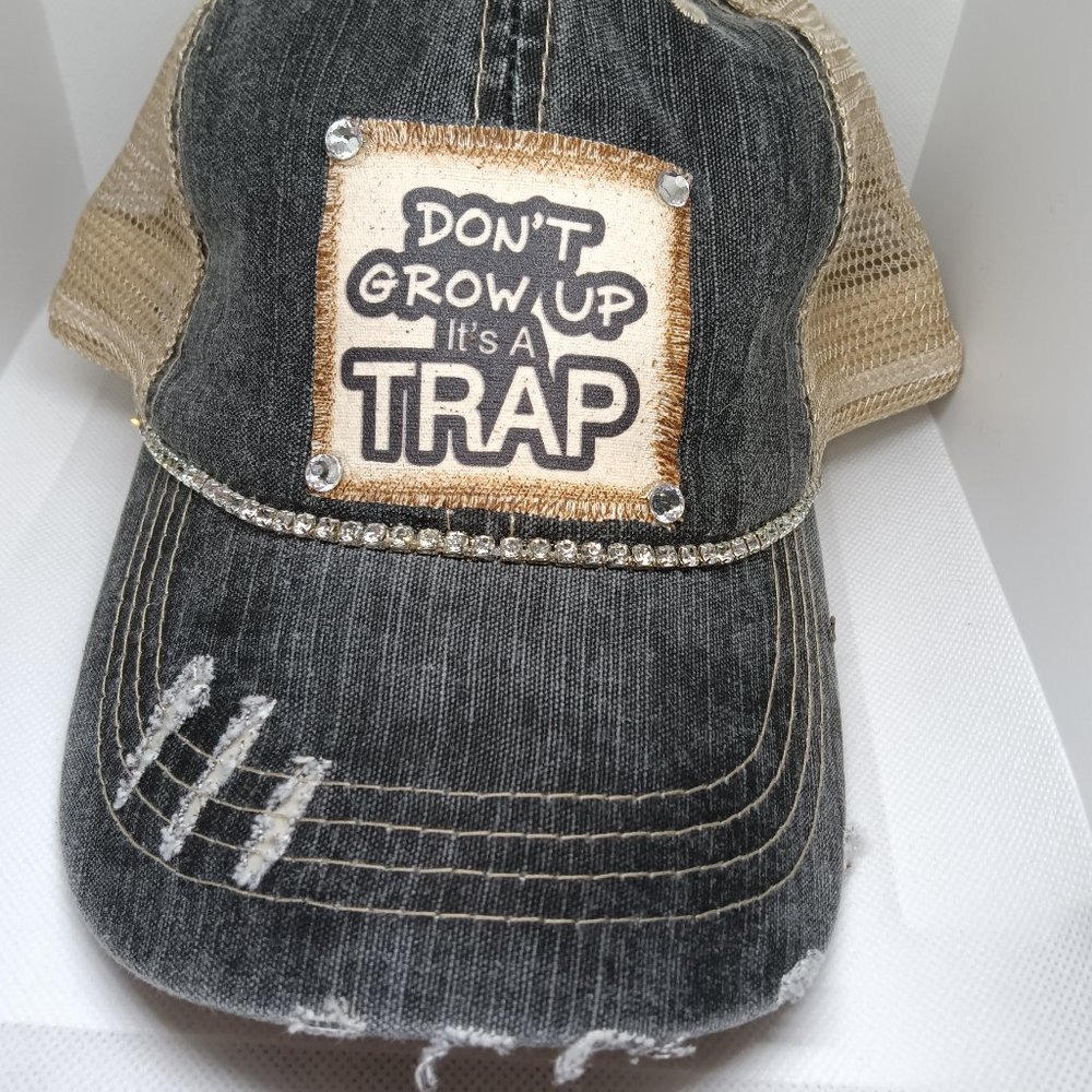 A distressed cap with a fun message " DON'T GROW UP It's A TRAP